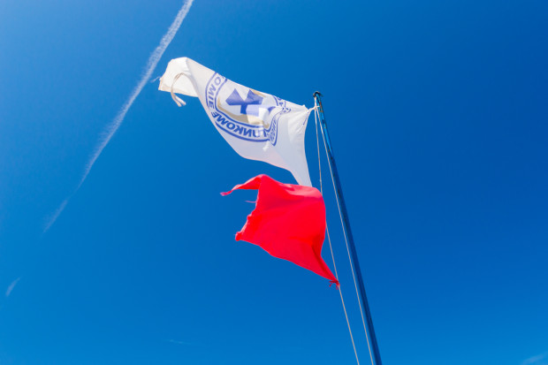 Na plaży przy Jeziorze Gałęźnym w Kościerzynie wywieszono czerwoną flagę. To oznacza zakaz wchodzenia do wody (fot. Shutterstock)