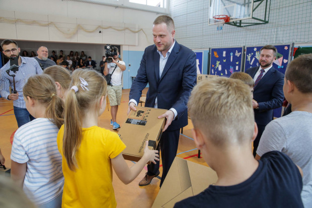 Uczniowie SP w Dywitach otrzymali laptopy z rąk ministra Janusza Cieszyńskiego i wójta Daniela Zadwornego. Takie m.in. zdjęcie zostało dołaczone do "kłamliwego" artykułu (fot. PAP/Tomasz Waszczuk).